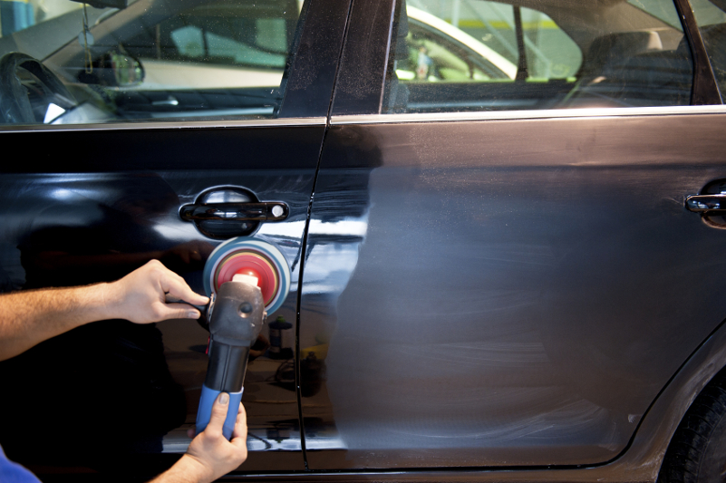 a black car being polished by Logan's Auto Detailing & Ceramic Coating