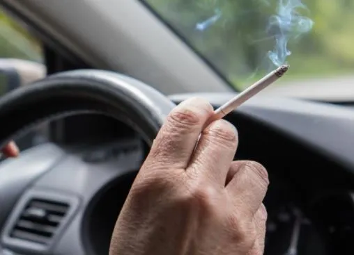 man smoking a cigarette in a car